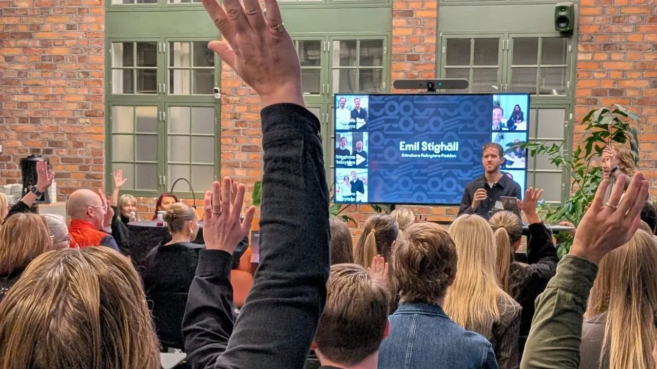 Emil Stighäll föreläser om employer branding inför en publik med uppsträckta händer